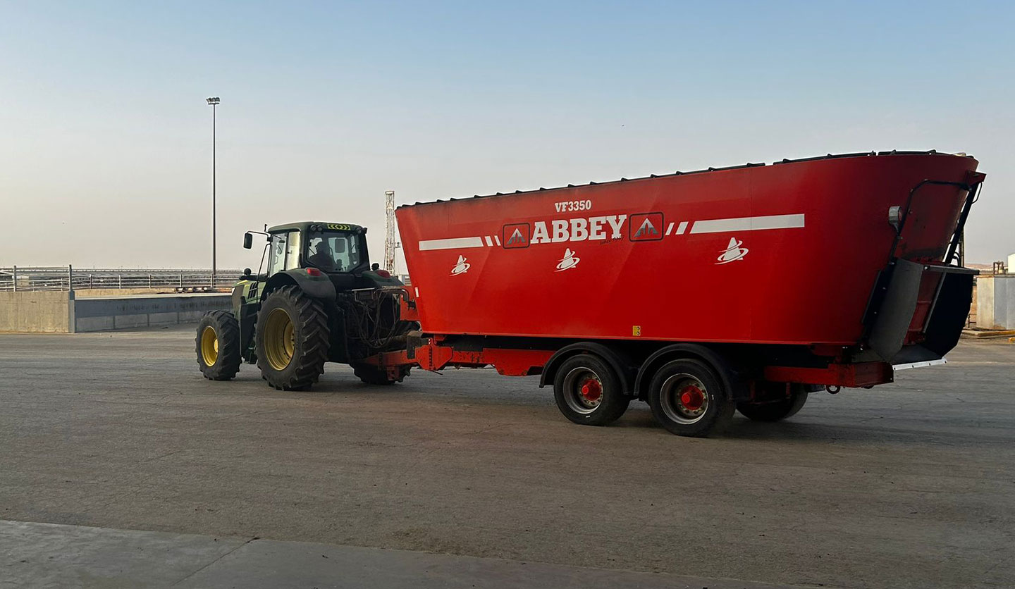 Abbey Machinery Tri-Auger Diet Feeder hitched to tractor