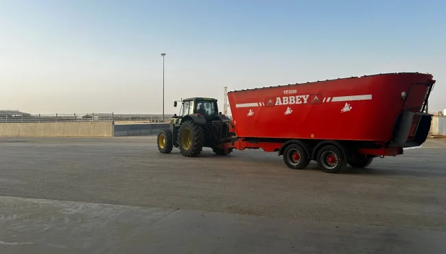 Abbey Machinery Tri-Auger Diet Feeder hitched to tractor